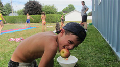 Camp de jour 2012 – Garçon attrapant une pomme dans l'eau avec sa bouche